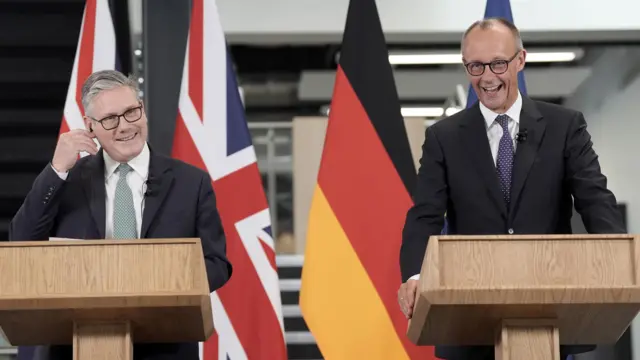Prime Minister Sir Keir Starmer and German Chancellor Friedrich Merz hold a press conference, standing side by side in dark suits smiling.