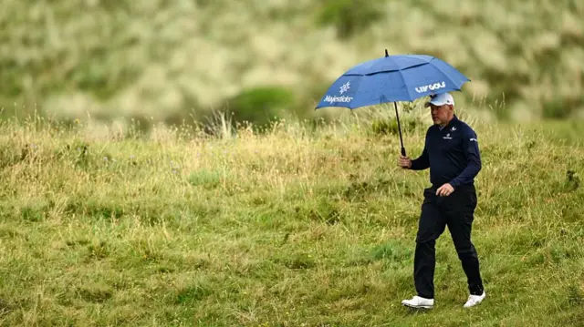 Lee Westwood under an umbrella at the 153rd Open at Royal Portrush