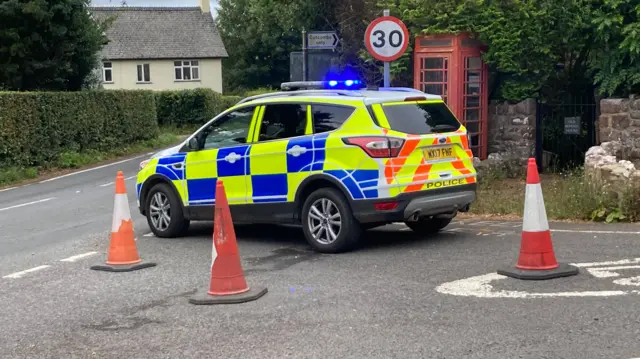 Police car in front of a red phone box