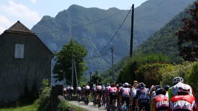 Riders approaching a mountain on stage 12 of the 2025 Tour de France