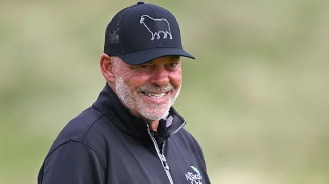 Darren Clarke in a black cap and jacket