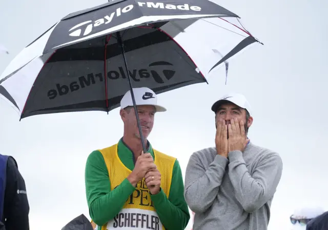 Scottie Scheffler with his caddy under the umbrella at The Open.