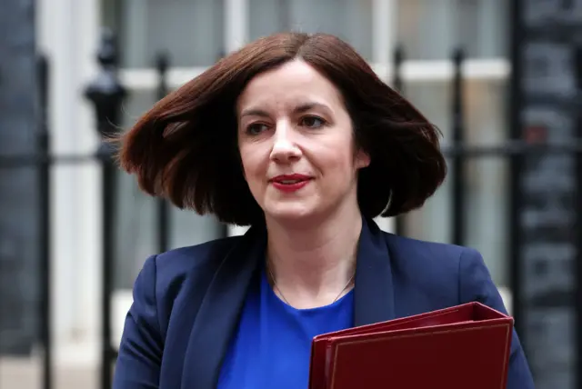 Education Secretary Bridget Phillipson walks towards the camera wearing a light blue top and dark blue jacket