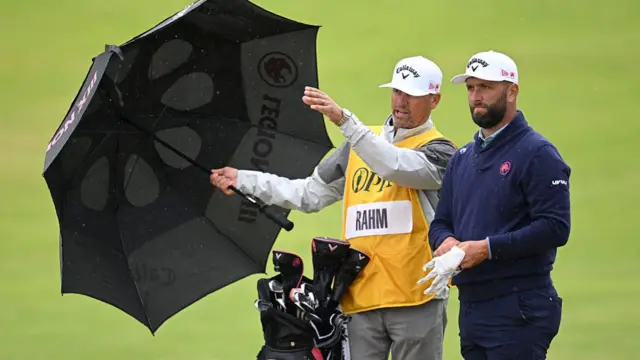 Jon Rahm watches on with his caddy during the 153rd Open Championship at Royal Portrush