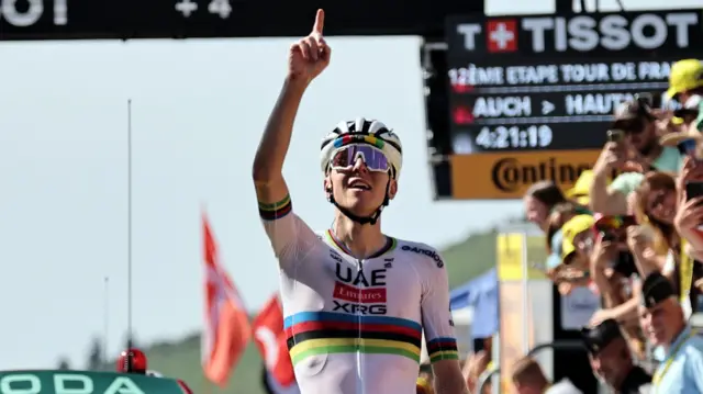 Tadej Pogacar points to the sky after winning stage 12 of the 2025 Tour de France
