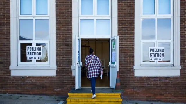 A woman walking into a polling station