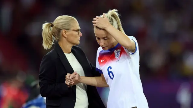 Leah Williamson of England is embraced by Sarina Wiegman, Head Coach of England, after leaving the pitch