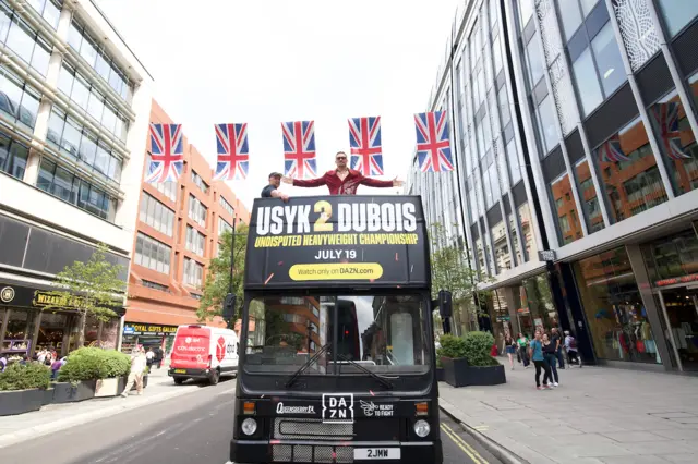 Oleksandr Usyk stands on the top floor of an open top bus in London