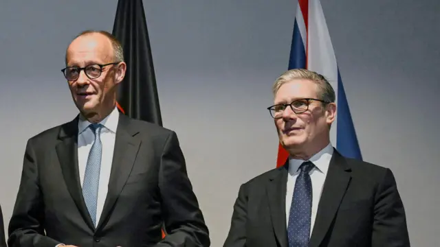 Friedrich Merz and Keir Starmer pose for the media during a NATO summit in The Hague, Netherlands.