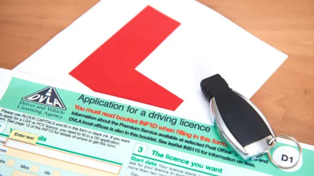 Learner plate and car keys on an application for a driving license