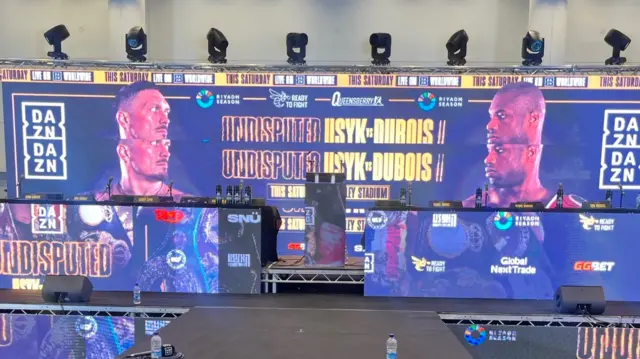 A table and big screen at Oleksandr Usyk v Daniel Dubois news conference