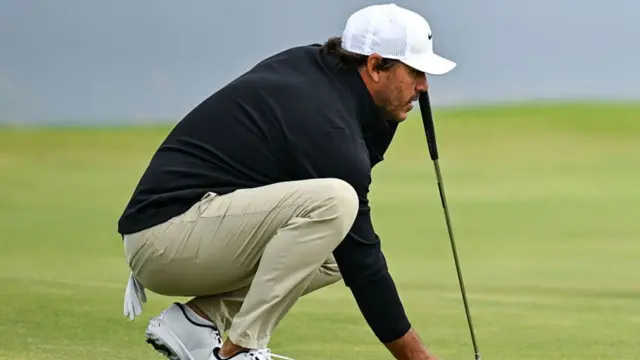 Brookes Koepka squats down to read the green before a putt at The Open Championship