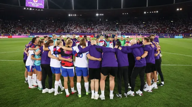 Players and staff of England huddle after the teams victory and progression to the semi-final