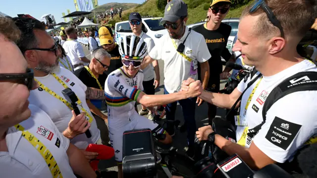 Tadej Pogacar celebrates with a team member after winning stage 12 of the 2025 Tour de France