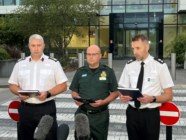 Members of the emergency services line up for a press conference