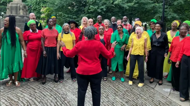 A choir is singing outside St Mary Redcliff Church