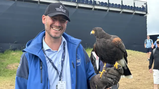 A man with a hawk on his fingers