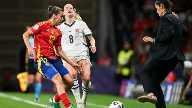 Spain's midfielder #12 Patricia Guijarro fights for the ball with Switzerland's defender #08 Nadine Riesen next to Spain's head coach Montse Tome