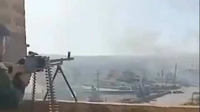 A fighter shoots a machine gun from a mounter position in Syria.