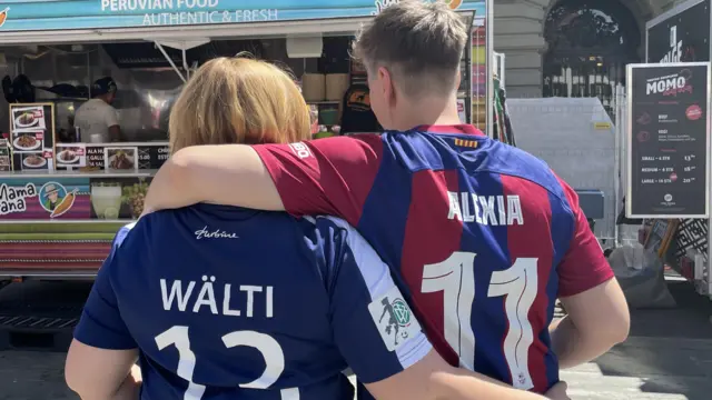 German couple, Christin and Anja, wearing opposition shirts and embracing