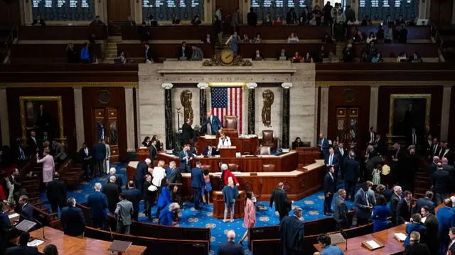 Inside chamber of the US House of Representatives during voting session. Several members seen walking around the room in formal office wear