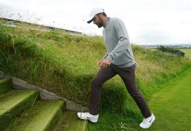 Scottie Scheffler steps onto some grassy steps