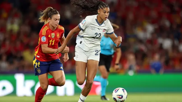 Sydney Schertenleib of Switzerland runs with the ball under pressure from Alexia Putellas of Spain