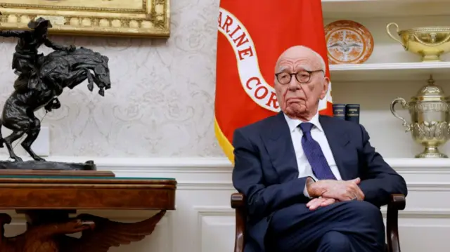 Rupert Murdoch sat on a chair in the Oval Office, wearing a suit with arms crossed