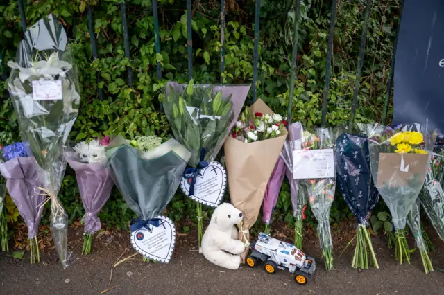 Floral tributes and toys left outside of the school gates