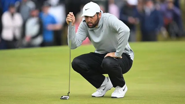 Scottie Scheffler squatting down to read the green at The Open 2025