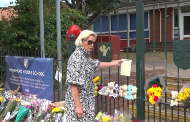 Rachel Gilmour, MP for Tiverton and Minehead, posting a letter among floral tributes outside of Minehead Middle School