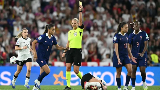 wedish referee Tess Olofsson (C) shows a yellow card to France's defender #02 Maëlle Lakrar