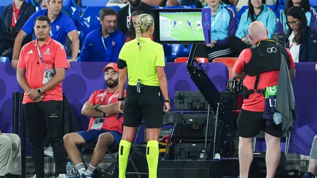 Referee Tess Olofsson stands in front of the VAR screen as she reviews a goal scored by Onema Grace Geyoro of France (not pictured) resulting in it being dissallowed for offside