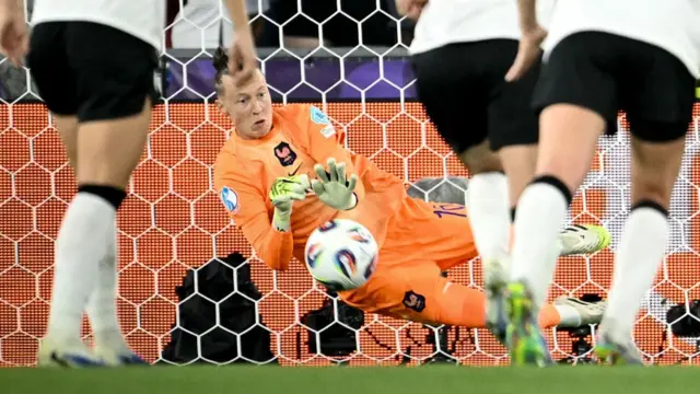 France's goalkeeper Pauline Peyraud-Magnin dives to save a penalty kick