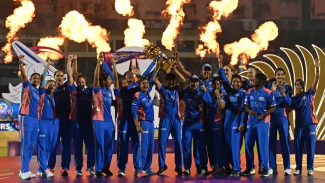 Mumbai Indians' players celebrate with the winning trophy at the end of the Women's Premier League