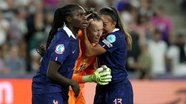 Pauline Peyraud-Magnin of France celebrates with team mates Griedge Mbock Bathy and Selma Bacha of France after saving a penalty taken by Sjoeke Nuesken of Germany