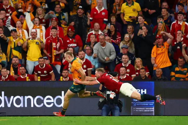 Max Jorgensen of the Wallabies breaks to score a try whilst being tackled by Finn Russell