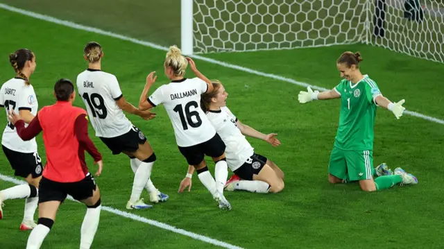Ann-Katrin Berger of Germany celebrates with teammates after saving a penalty kick from Sakina Karchaoui of France, (not pictured), winning the penalty shootout for her team