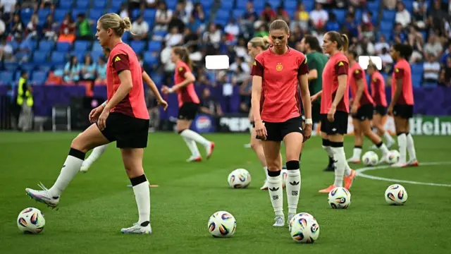 Germany's defender #04 Rebecca Knaak, Germany's midfielder #22 Jule Brand and teammates take part in a warm-up session