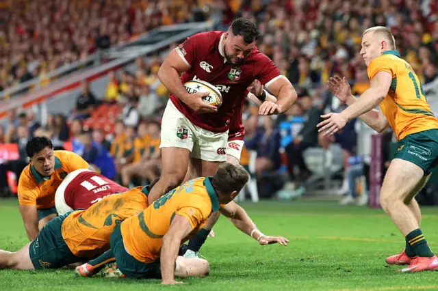 British and Irish Lions' Ellis Genge (C) evades a tackle