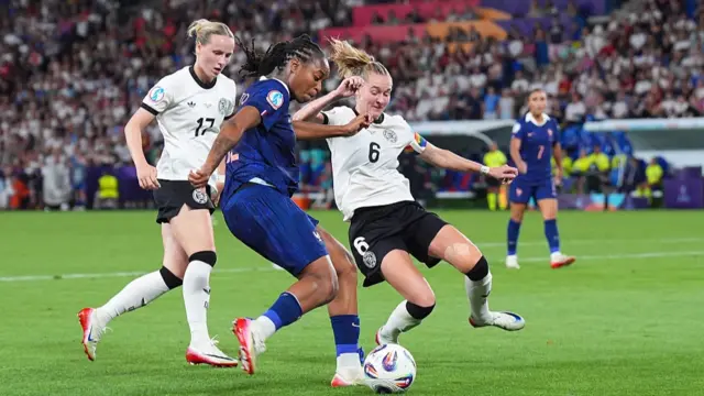 Franziska Kett of Germany (L) and Janina Minge of Germany (R) defend against Marie Antoinette Katoto of France (C)