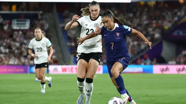 Sakina Karchaoui of France runs with the ball under pressure from Jule Brand of Germany