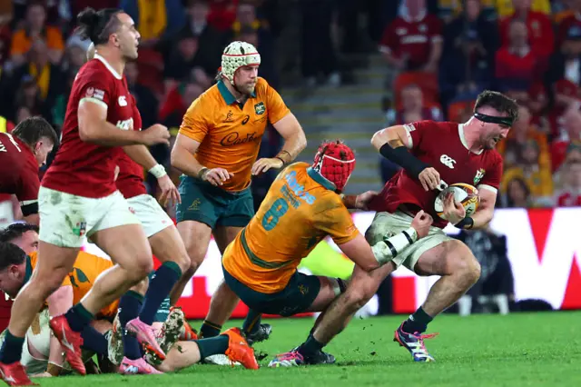 Australia's Harry Wilson (C) tackles British and Irish Lions' Tom Curry