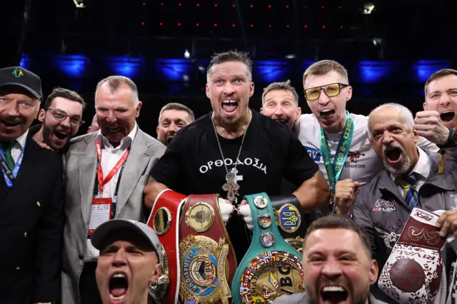 Usyk and his team celebrate the win with the belts