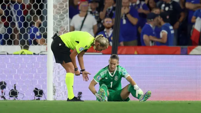 Referee Tess Olofsson interacts with Ann-Katrin Berger of Germany