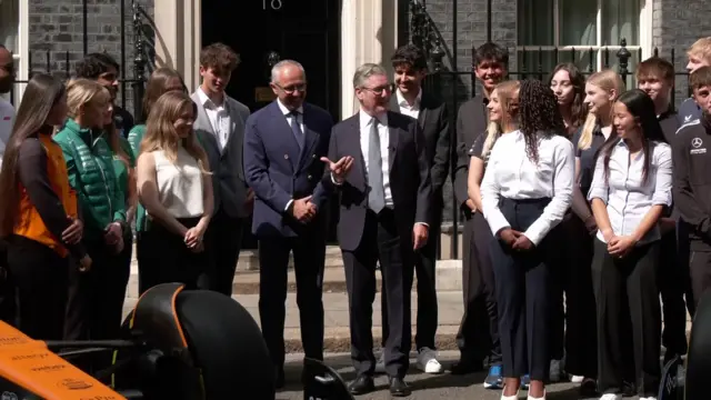 Starmer gestures as he speaks surrounded by young people