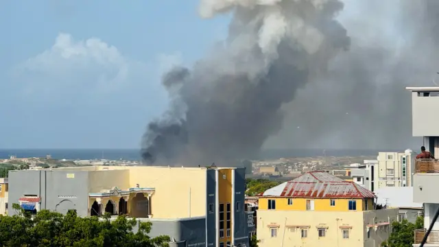 Thick smoke rising in the direction of Aden Adde airport after the helicopter crash with rooftops in the foreground