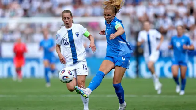 Glodis Viggosdottir of Iceland passes the ball whilst under pressure from Linda Saellstroem of Finland during the UEFA Women's EURO 2025 Group A match between Iceland and Finland at Arena Thun