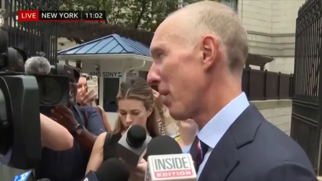 Doug Wigdor, a man in a suit, speaks to reporters