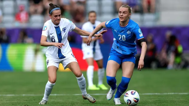 Gudny Arnadottir of Iceland runs with the ball under pressure from Joanna Tynnila of Finland during the UEFA Women's EURO 2025 Group A match between Iceland and Finland at Arena Thun